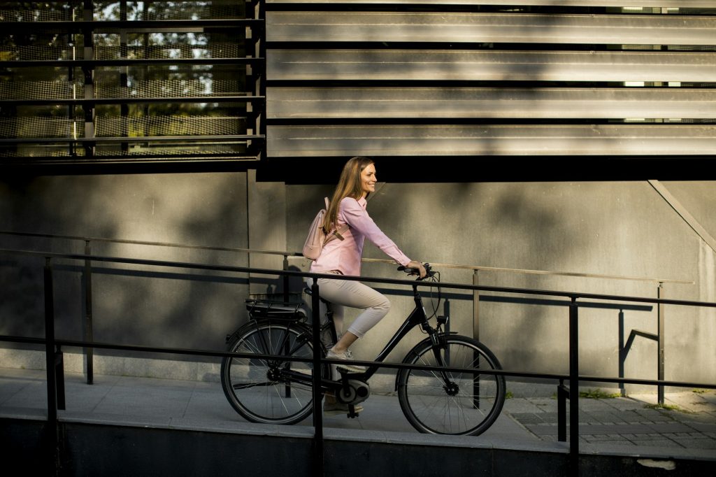 Young woman riding e bike in urban enviroment